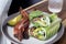 Closeup of the lettuce wraps with bacon and avocado on a gray plate with a glass of iced water