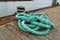Closeup of a light blue tangled rope attached to a metallic handle on the harbor