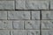 Closeup of light gray unpainted brick veneer wall
