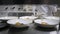 Closeup Line of plates dishes. Group chefs busy in commercial kitchen of fine dining restaurant. Staff in a restaurant