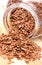 Closeup of linseed pouring out of glass jar