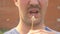 Closeup. lips of a mustachioed man blow on a dandelion