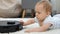 Closeup of little baby boy looking on rotating brushes of robot vacuum cleaner. Concept of hygiene, household gadgets