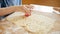 Closeup of little boy cutting biscuit dough with plastic cutter form. Children cooking with parents, little chef, family