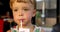 Closeup of little boy drinking milk with straw