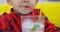 Closeup of little child drinking Mojito with straw in a fast food restaurant