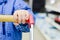 Closeup on little child hand holding shopping trolley, blue jacket