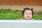 Closeup little girl catch a white fence on grass floor in the garden background with smile face