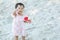 Closeup little girl play with sand and toy on beach textured background with copy space