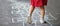 Closeup of little girl`s legs and hop scotch drawn on asphalt. Child playing hopscotch game on playground outdoors on a sunny day