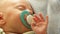 Closeup little newborn baby girl sleeping with dummy in mouth. Full HD