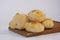Closeup of loaves of traditional Paraguayan chipa cheese bread on a wooden tray in a bright kitchen