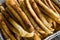 Closeup of a long sticks of Fried Lumpia in an aluminum tray