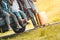 Closeup lower body of group of friends relaxing on SUV car trunk with trolly luggage along road trip with autumn mountain hill