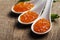 Closeup of luxury red caviar in white spoon with parsley on wood