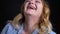 Closeup macro portrait of adult caucasian female looking at camera smiling happily and tossing her blond hair