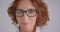 Closeup macro portrait of adult redhead caucasian businesswoman in glasses looking at camera smiling happily indoors in