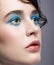 Closeup macro portrait of female face. Woman with unusual beauty makeup and wet hair, and blue shadows make-up