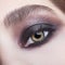 Closeup macro portrait of human female eye with violet - black smoky eyes make-up