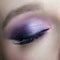 Closeup macro shot of human female eye. Woman with lilac beauty eyes makeup