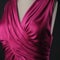 A closeup of a magenta dress with a deep vneck and ruched sides. Trendy color of 2023 Viva Magenta.. AI generation