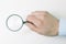 Closeup.magnifier in the hand of businessman. isolated on a white background.