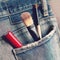 Closeup makeup tools in back jeans pocket