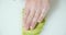 Closeup male cook hands in gloves serving slices of ripe avocado on a white board.
