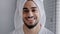 Closeup male face with acne headshot portrait smiling toothy handsome arabian indian bearded man with bath towel on head