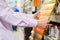 Closeup on male or female hands choosing paint for wood in DIY department shop