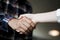 Closeup of male and female hands handshaking after effective negotiation showing mutual respect. Two people handshaking expressing