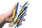 Closeup of male hand holding group of simple pencils and pens used for drawing and creative sketching. various writing supplies