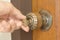 Closeup of male hand unlocking old door