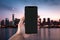 Closeup male hand unrecognizable business man holding smartphone city cityscape background downtown guy make photo