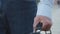 Closeup male hand, worker with briefcase, unrecognizable modern adult mature man elderly businessman or professor in