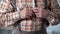 Closeup of male hands buttoning up checkered shirt, old-fashioned clothes