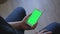 Closeup of male hands holding smart phone with green screen prekeyed for effects. Useful mobile application booking, ordering