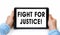 Closeup of a male hands holding tablet pc with text Fight for Justice. Isolated on white background