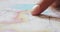 Closeup of male hands pointing on travel map places to visit. Tourist man planning summer vacation journey and poitining