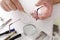 Closeup of male hands who fixing eyeglasses.Optical fixing kit, lens, screws and glasses on the white desk.Optical workshop