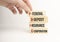 Closeup man add more some alphabets wood cubes into the row to complete the word fdic, converge benefits, mutal benefits concept