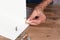 Closeup of a man assembling a DIY piece of furniture. The man is inserting a wooden dowel into a pre-drilled hole