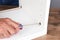 Closeup of a man assembling a DIY piece of furniture. The man is using a screwdriver to tighten a piece of hardware