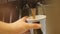 Closeup man fills blue paper cup with fresh hot coffee