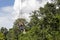 Closeup of a man gliding on extreme trolley zipline in adventure park with cloudy blue sky background in sunny day..