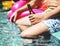 Closeup of man hand holding beer bottle by the poolside