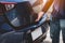 Closeup of man hand opening hatchback trunk by touching sensor door. People lifestyle and transportation technology. Travel and