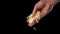 Closeup of man hand sprinkle grated cheese mozzarella over dark background.