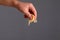 Closeup of man hand sprinkle grated cheese over dark background. Healthy food