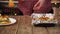 Closeup of man hands cutting enchilada by wooden paddle and putting it from casserole to a plate